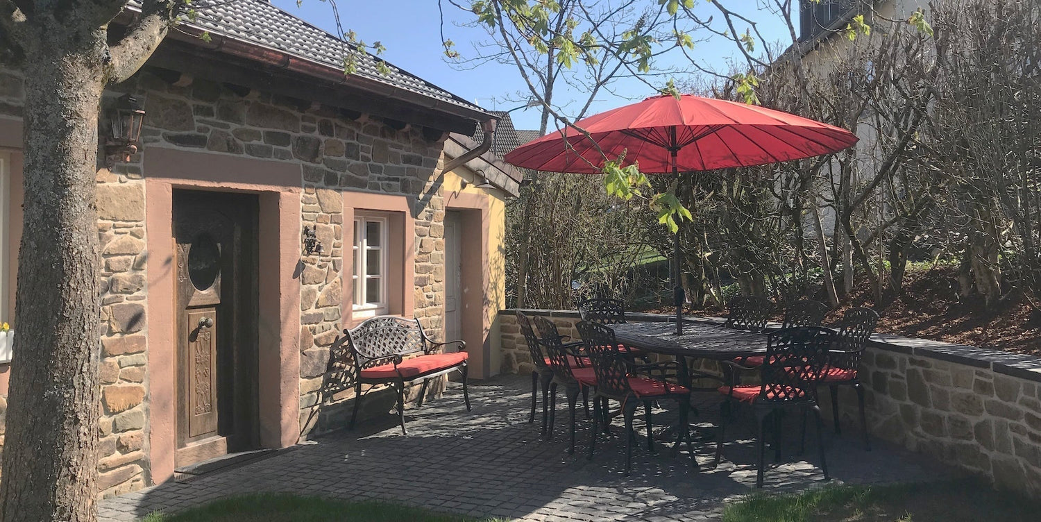 Which garden furniture sets come with a parasol or protective cover?