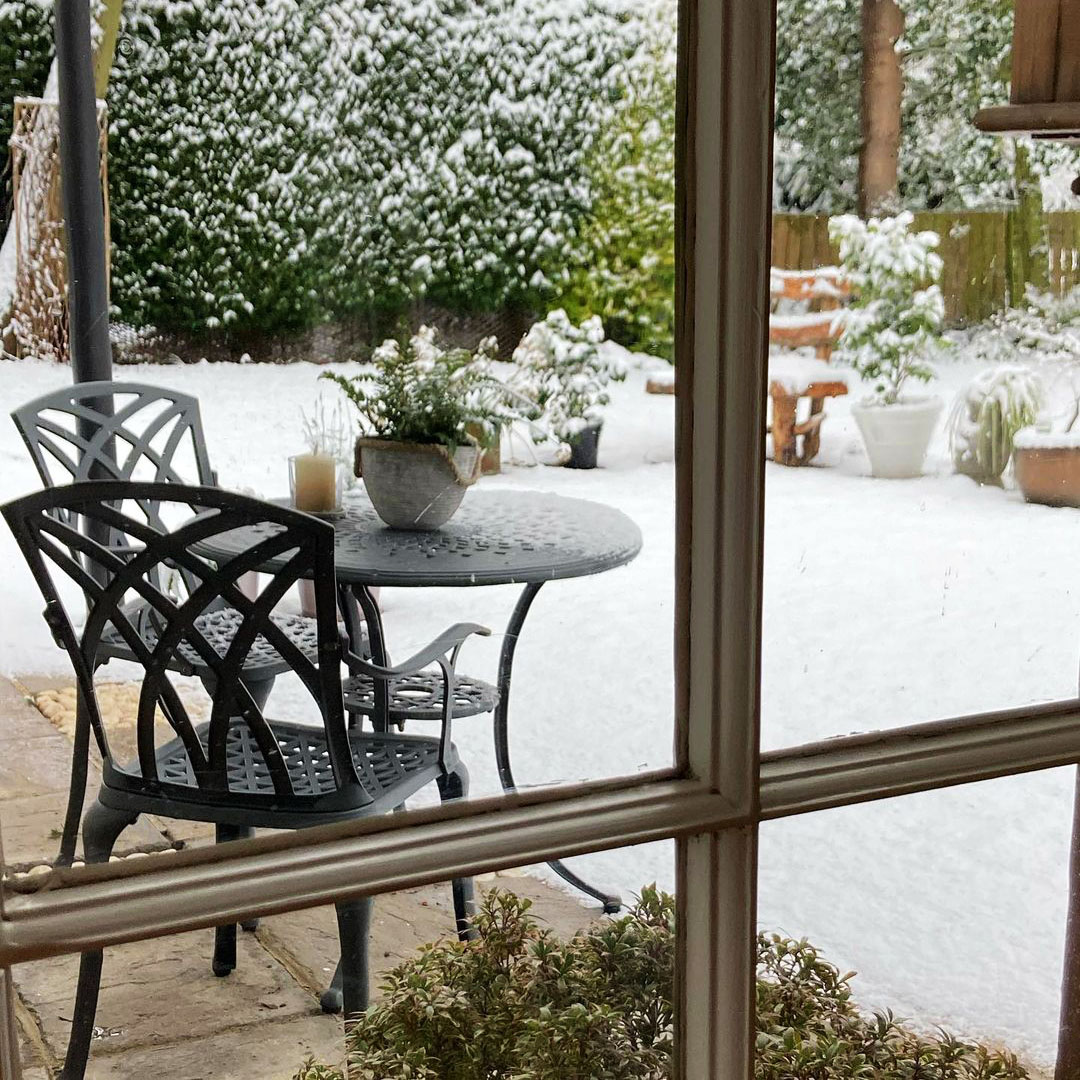 Schwarzes ANNA Gartentisch-Set auf Terrasse mit schneebedecktem Garten