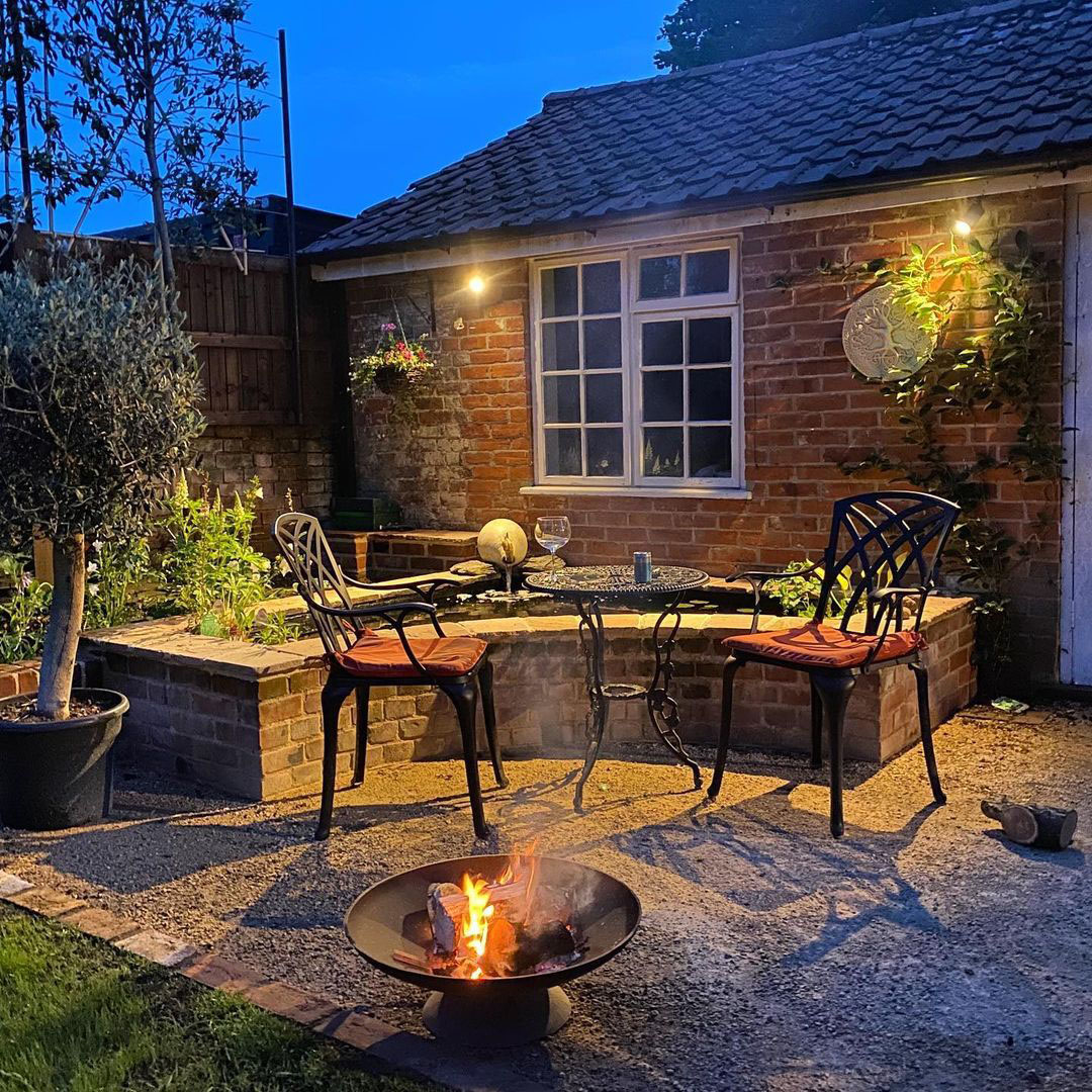 A customer photo of our London Rose Bistro Set with a fire pit